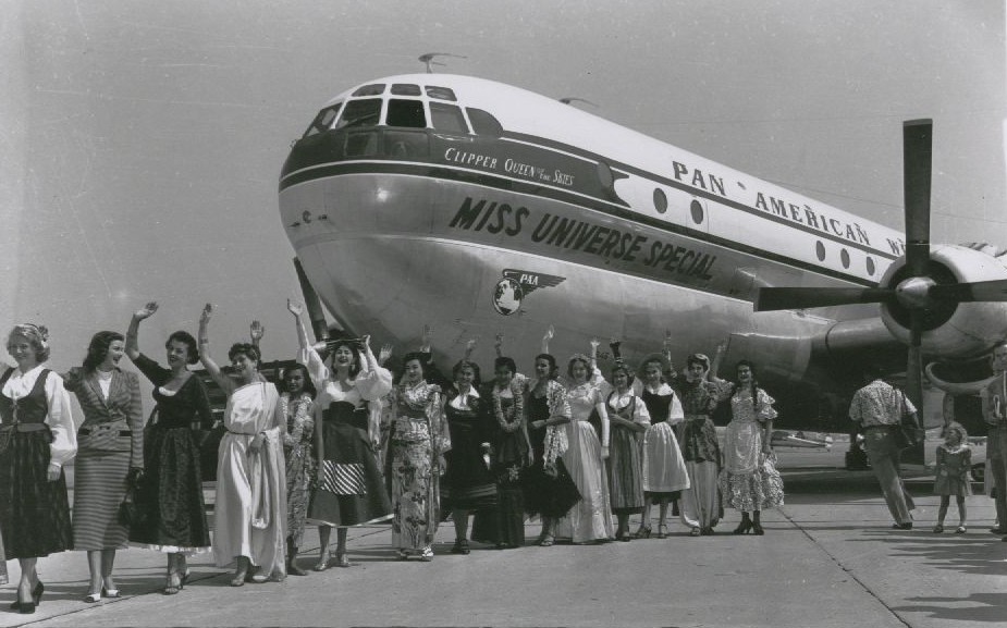 1953 Pan Am renames a Boeing 377 Stratocruiser for the Miss Universe competition while some of the contestants pose by the aircraft.
